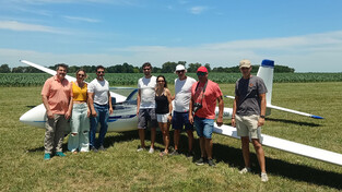 Gruppenfoto von Personen neben einem SZD-54-2 Perkoz auf einer Wiese.